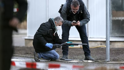 A police officer examines a weapon near the crime scene in Heidelberg. EPA