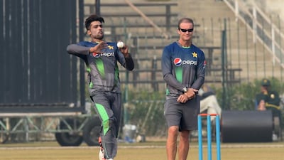 Pakistan cricket batting coach Grant Flower, right, watches as bowler Mohammad Amir delivers a ball during a team practice session at a camp ahead of the New Zealand tour, in Lahore on January 2, 2016. AFP PHOTO / Arif ALI