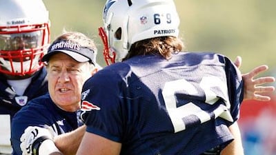 Bill Belichick, the New Engalnd Patriots head coach, gives hands on training to rookie defensive end Alex Silvestro during a recent training camp in Foxborough, Massachusettes.