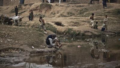An Afghan refugee, cleans himself in a polluted stream on the outskirts of Islamabad, Pakistan. Pakistan hosts over 1.6 million registered Afghans, the largest and most protracted refugee population in the world, according to the U.N. refugee agency, thousands of them still live without electricity, running water and other basic services. Muhammed Muheisen / AP Photo