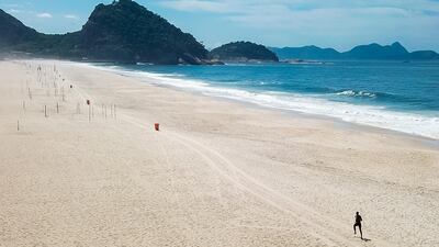 A man jogs on Copacabana beach in Rio de Janeiro, Brazil. Getty Images