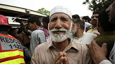An Ahmedi muslim man weeps as victims are loaded onto an ambulance after gunmen attacked their mosque in Lahore's Garhi Shahu neighbourhood.