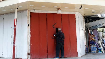 An Iraqi man buys liquor from a closed shop, that is selling illegaly through a window, in the capital of Baghdad on October 23, 2016. The Iraqi parliament voted a day earlier to ban the sale, import and production of alcohol. Sabah Arar/AFP