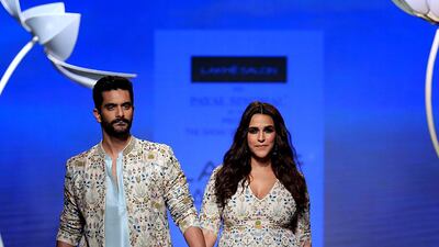 Actress Neha Dhupia and husband Angad Bedi walk for Payal Singhal. AFP