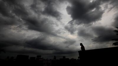 A girl is against a background of dark monsoon rainclouds looming in the sky before heavy rains in Calcutta. Piyal Adhikary / EPA