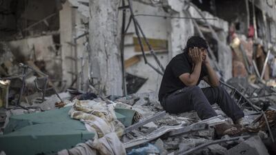 A Palestinian man sits outside his destroyed house in Beit Hanoun. Oliver Weiken / EPA