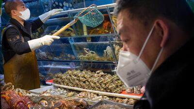 A customer wears a face mask as he shops for seafood at a market in Beijing. AP Photo