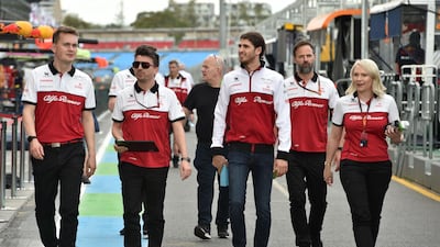 Alfa Romeo's Italian driver Antonio Giovinazzi (3rd R) walks down pit lane with team members at the Albert Park circuit ahead of the Formula One Australian Grand Prix in Melbourne. AFP