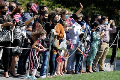 Guests wear protective masks gather to greet as US President Donald Trump on the South Lawn of the White House as he departs for a roundtable with supporters in Bedminster, New Jersey. EPA, POOL