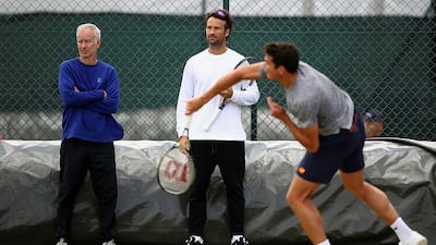 Milos Raonic of Canada is watched by his coaches John McEnroe and Carlos Moya during a practice session prior to the Wimbledon Lawn Tennis Championships at the All England Lawn Tennis and Croquet Club on June 26, 2016 in London, England. Clive Brunskill/Getty Images