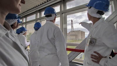 Tour guide Jurgita Norvaisiene points at the inoperative Ignalina nuclear power plant during a guided tour in Visaginas.