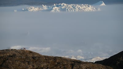 A massive iceberg peeks out from fog in the Ilulissat Icefjord. Getty Images
