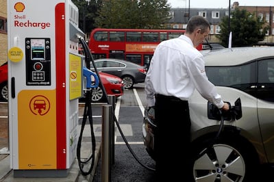A member of staff charges an electric car at the Holloway Road Shell station where Shell launched its first fast electric vehicle charging station in London, UK. Reuters