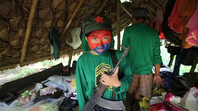 In this November 23, 2016 photo, a New People's Army guerrilla holds her firearm at a rebel encampment southeast of Manila, Philippines. AP