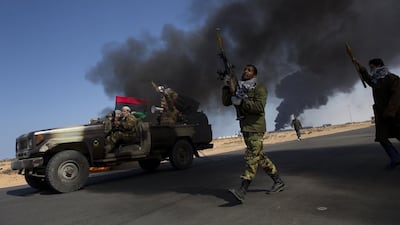 Opposition troops burn tires to use as cover during heavy fighting, shelling, and airstrikes near the main checkpoint near the refinery in Ras Lanuf as rebel troops pull back from Ras Lanuf, in Eastern Libya, 2011. Courtesy Lynsey Addario