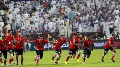 Al Ahli players rush to the goal after goalkeeper Majed Naser turned a matchwinner in the penalties. Satish Kumar / The National