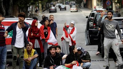 Protesters gesture towards a driver at a roadblock during ongoing anti-government demonstrations in Beirut, Lebanon. Reuters