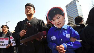 Anti-government activist, with one wearing a mask of South Korea's president Park Geun-hye, march toward the presidential Blue House after the announcement of the Constitutional Court's decision to uphold the impeachment of Park in Seoul on March 10, 2017, over a wide-ranging corruption scandal. Jung Yeon-Je / AFP
