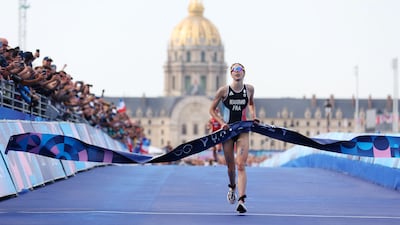 PARIS, FRANCE - JULY 31: Cassandre Beaugrand of Team France crosses the finish tape to win the gold medal after competing in Women's Individual Triathlon on day five of the Olympic Games Paris 2024 at Pont Alexandre III on July 31, 2024 in Paris, France. (Photo by Michael Steele / Getty Images)