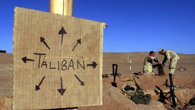 A 2001 photo of troops fortifying their light mortar position on the frontline of a US Marine Corps base, near a cardboard sign reminding everyone that Taliban forces could be anywhere, in southern Afghanistan. Reuters