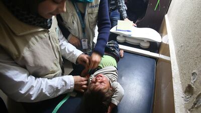 Unicef volunteers examine a child at a hospital in Al Shaffuniyah, in Eastern Ghouta, last month. Abdulmonam Eassa / AFP
