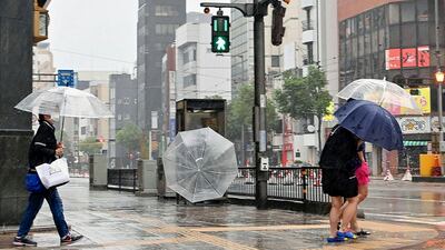 Pedestrians brave the bad weather in Matsuyama, Japan. AP