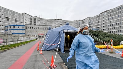 A paramedic walks out of a tent that was set up in front of the emergency ward of the Cremona hospital, northern Italy. AP