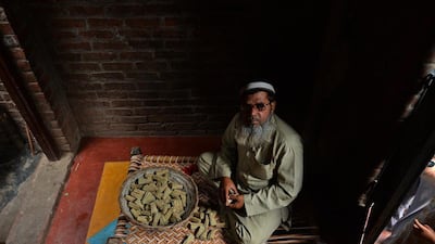 Muhammad Zaid, 50, looks on as he collects the bundles of bidis which he rolled, at his home in Kannauj.