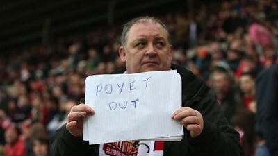 A Sunderland fan holds up a poster reading "Poyet out" during their Premier League loss to Aston Villa at the Stadium of Light on Saturday. Ian MacNicol / AFP