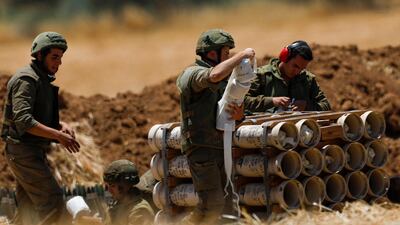 Israeli artillery soldiers prepare propelling charges for a howitzer at the border with Gaza. EPA