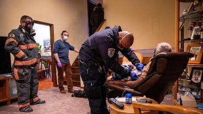 Emergency workers assesses a potential Covid-19 patient before transporting him to a hospital on December 15, 2020 in Yonkers, New York, US. Getty Images/AFP