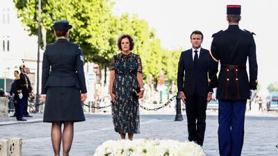 French President Emmanuel Macron stands next to British ambassador to France Menna Rawlings, after rekindling the flame under the Arc de Triomphe in Paris to mark the British queen's platinum jubilee. Reuters
