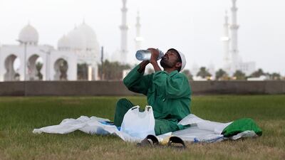 A man breaks his fast near the Sheikh Zayed Grand Mosque in Abu Dhabi. Regular water intake is vital for fasters’ health. Christopher Pike / The National