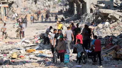 Palestinian families walk past destroyed buildings and rubble after the Israeli military withdrew from the Shujaiya neighbourhood, east of Gaza city. AFP