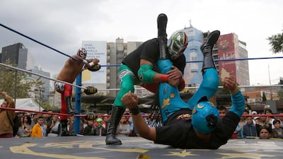 Mexican wrestler Rakner clashes with Relampago Veloz during a "lucha libre" fight in Mexico City, on Saturday, December 21. AP