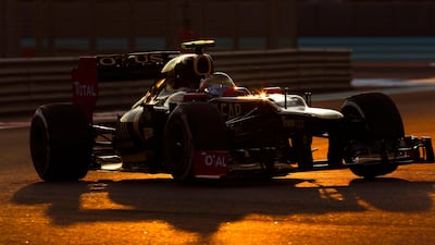 Romain Grosjean's Lotus catches the setting sunlight at Yas Marina Circuit. Valdrin Xhemaj/EPA