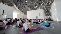 Participants gather under the dome of Louvre Abu Dhabi for a International Day of Yoga celebration. Ryan Lim for The National