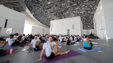 Participants gather under the dome of Louvre Abu Dhabi for a International Day of Yoga celebration. Ryan Lim for The National