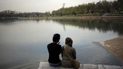 A couple sits by the bank of Zayandeh Rud river in the city of Isfahan. Many Iranians struggle daily to develop romantic relationships in the face of their regime's harsh social dictates.
