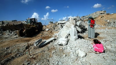 Ebtesam Khader, 35, holds her baby as she looks at the remains of her house that was destroyed during the military conflict between Israel and Hamas that took place during the winter of 2008/2009, at the Jabaliya Refugee Camp, in the Gaza Strip, 13 November 2009. EPA/ALI ALI