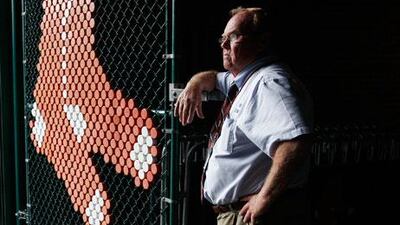 A security officer at Boston's Fenway Park opens the gates to welcome the media last week the day after the Red Sox missed out on a play-off berth.