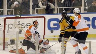 Boston Bruins left wing Marco Sturm, centre, of Germany, scores the game-winning goal in overtime in front of Philadelphia Flyers goalie Michael Leighton (49) and defenceman Braydon Coburn (5) in the New Year's Day Winter Classic NHL hockey game on an outdoor rink at Fenway Park in Boston.