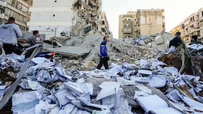Documents of Hezbollah-run Al Qard Al Hassan are scattered at the site of an Israeli air strike on Sunday night in the southern suburbs of Beirut, Lebanon. AP