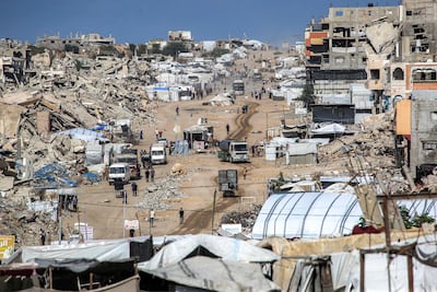 Vehicles drive past collapsed buildings and temporary shelters in the Jabalia camp in the northern Gaza. AFP