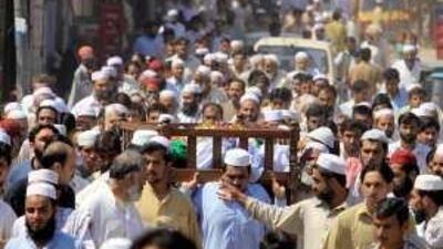 People carry the body of a victim of the suicide attack on Peshawar's Pearl Continental hotel for burial yesterday.