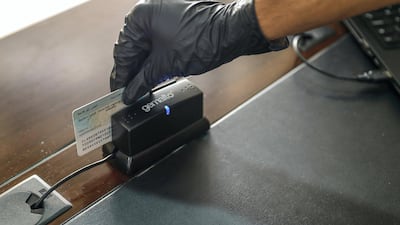 An Emirates ID card swiped at the entrance. Worshippers must also register online first and wait for email confirmation.