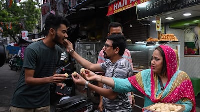 Bangladeshis living temporarily in India distribute after Sheikh Hasina’s resignation, in Kolkata. AFP