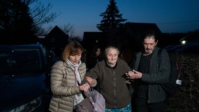 Iryna Starkova and her husband Anatolii Subota help Ludmila into their new home. The family of 10 range in age from Alikhan, 10, to great-grandmother Ludmila, 90.