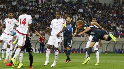 Japan forward Keisuke Honda, right, dives to score the opening goal of the game. Shuji Kajiyama / AP Photo