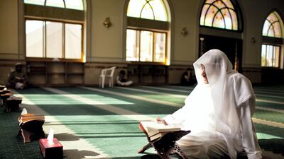 A man reads passages of the Quran during his afternoon prayers at a mosque on the outskirts of the Khalidiya neighborhood in Abu Dhabi, August 1, 2011. Silvia Razgova / The National